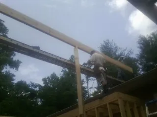 Carpenter setting a ridge beam over a new addition frame — Ice Dam Removal by Roofing Brothers in Imnaha