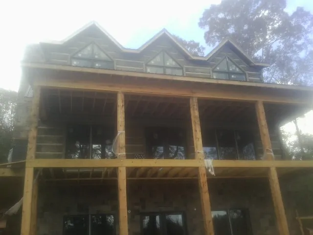 Dormers and porch framing on a large log home under construction — Roof Coating work by our crew in Imnaha