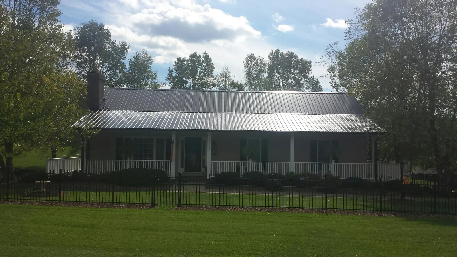 Gray metal roof on a brick ranch with a full width front porch — Gutter Guard Installation work by our crew in Imnaha