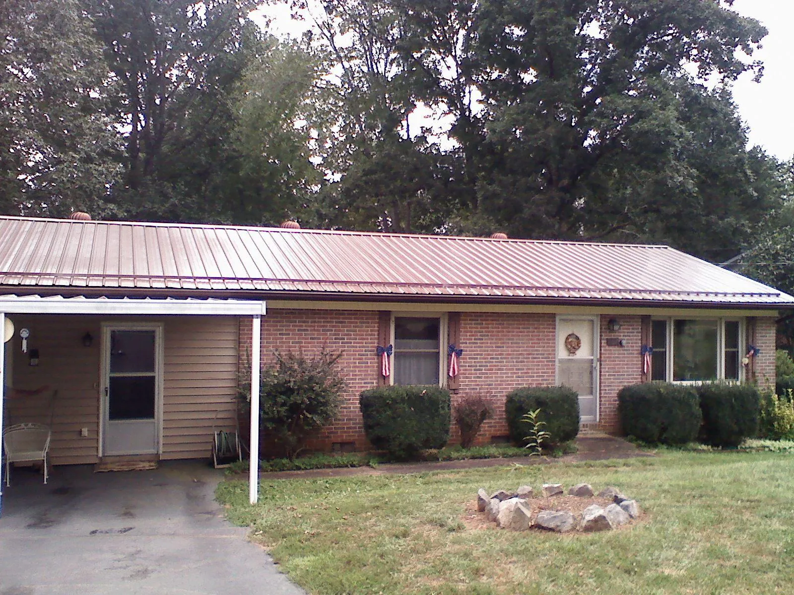 Bronze metal roof and carport on a brick ranch home — Roof Repair work by our crew in Imnaha