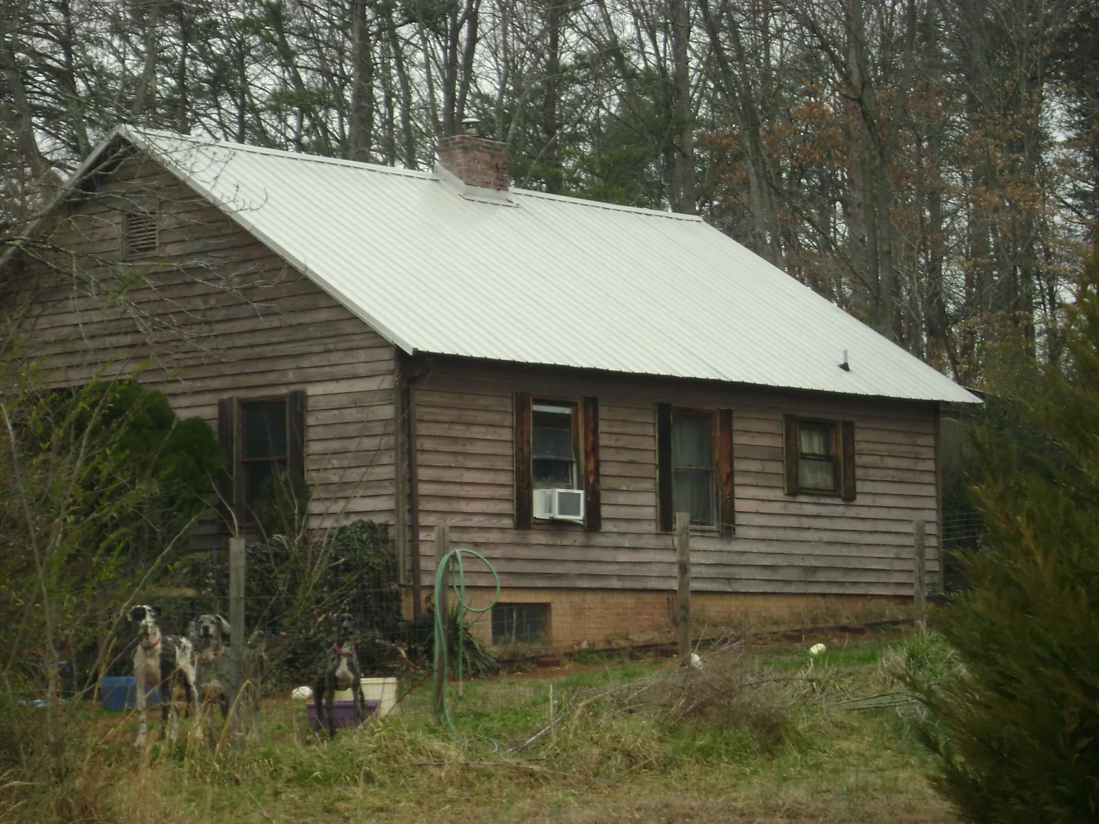 White metal roof on an old wood sided farmhouse, from a Metal Roof Installation job in Imnaha